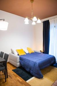1 dormitorio con cama con edredón azul y sofá en Delightful shanti home en Milán