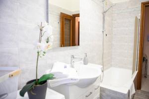 a white bathroom with a sink and a mirror at Delightful shanti home in Milan