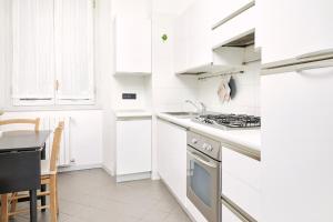 Biała kuchnia z kuchenką i zlewem w obiekcie PRESTIGE BOUTIQUE HOMES - Duomo 2 w Mediolanie