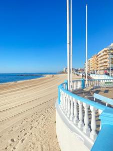 a view of a beach with a blue railing at Daria in La Mata