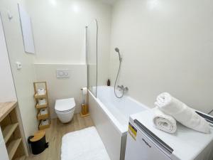 a white bathroom with a tub and a toilet at Luxury City Retreat with Terrace in Košice