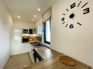 una cucina con un orologio sul muro di Luxury City Retreat with Terrace a Košice