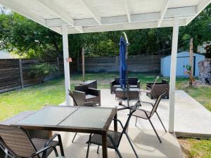 un patio con mesa, sillas y sombrilla en San Antonio Comfort 4 Bedroom 3 Bath home 5 Mins from Sea World en San Antonio