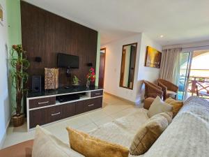 een woonkamer met een bank en een tv bij Pipa Paradise in Pipa