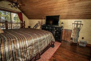 a bedroom with a bed and a flat screen tv at How Sweet It Is~ Downtown Village Retreat Cabin~ Walk to Marinas and Shopping in Big Bear Lake