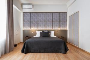a bedroom with a bed with a black bedspread at Anaktora Luxury Apartment at Kolonaki in Athens