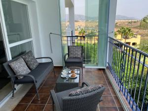 a balcony with chairs and a coffee table on a balcony at Apartment Summer Vibes Miraflores - La Cala de Mijas in La Cala de Mijas