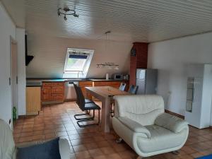 a kitchen with a table and a couch and a chair at Ferienwohnung Elena 2 in Zweibrücken
