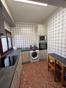 a kitchen with a washing machine and a washer and dryer at Apartamento JUMIDOSIV in Aliaga