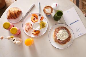 a table with two plates of breakfast foods and drinks at The Maybourne Beverly Hills in Los Angeles