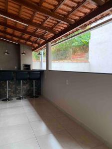an empty room with a counter and a large window at Casa moderna e confortável 2andar in Leopoldina