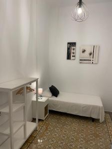 1 dormitorio con cama, mesa y estante en Des Artistes, en Barcelona