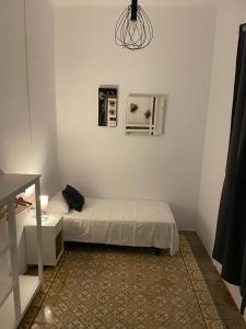 a small room with a bed and a table and a bed sqor at Des Artistes in Barcelona