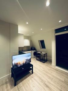 a living room with a large flat screen tv at Modern flat in Victoria in London