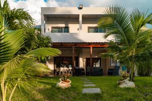 une maison avec des palmiers devant elle dans l'établissement Stella Marris beachfront villa, à Pointe aux Sable