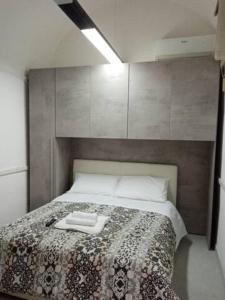 een slaapkamer met een bed met een handdoek erop bij Notti al Vesuvio in Boscoreale