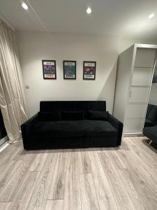 a black couch sitting in a living room at Modern flat in Victoria in London