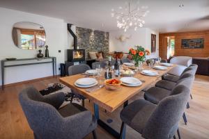 a dining room with a wooden table and chairs at Le Grand Bossonnet - OVO Network in La Clusaz