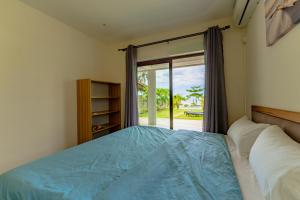 Schlafzimmer mit einem Bett und einer Glasschiebetür in der Unterkunft Stella Marris beachfront villa in Pointe aux Sable