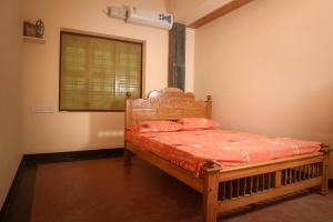 a bedroom with a wooden bed with red sheets at Villa in the woods in Trichūr