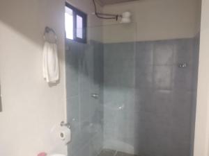 a bathroom with a shower with a glass door at Villas El Alto 4 in Cóbano