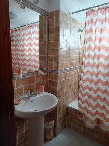Un baño con lavabo y cortina de ducha. en Palmeras del Sur Juan, en Playa de las Américas