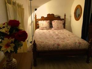 Schlafzimmer mit einem Bett mit rosa Kissen und Blumen in der Unterkunft Appartement RDC dans jolie parc Arboré in Beure