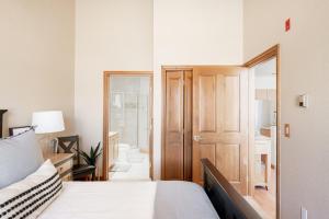 a bedroom with a bed and a wooden door at Mountain Views Galore - Avon Condo - Walk to Town in Avon