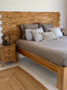 a bedroom with a large bed with a wooden headboard at Les lodges de Salazie in Salazie