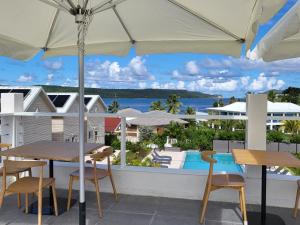 eine Terrasse mit Tischen und Stühlen und Meerblick in der Unterkunft Crawlbay Suites Hotel in Newfield