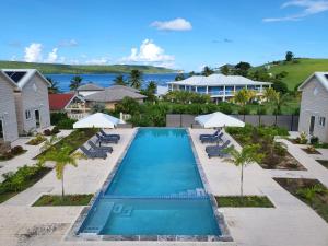 an overhead view of a swimming pool with chairs and umbrellas at Crawlbay Suites Hotel in Newfield