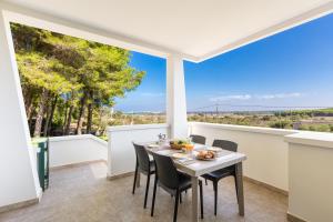 una sala da pranzo con tavolo, sedie e ampie finestre di Residenza del Timo a Gallipoli