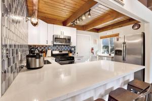 a kitchen with a white counter top and a refrigerator at Ursa Minor- Modern Resort Chalet- Hot Tub in Big Bear Lake