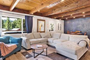 a living room with a large white couch and chairs at Ursa Minor- Modern Resort Chalet- Hot Tub in Big Bear Lake