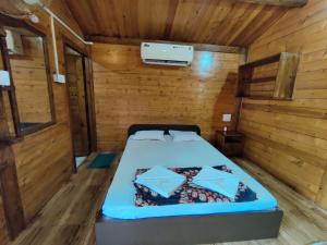 a bedroom with a bed in a wooden room at Pousada Donaciana - Beach Cottages in Baga
