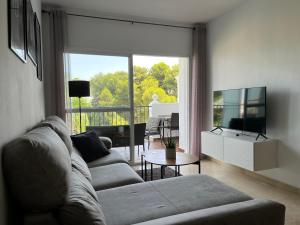 sala de estar con sofá y ventana grande en Apartment Summer Vibes Miraflores - La Cala de Mijas, en La Cala de Mijas
