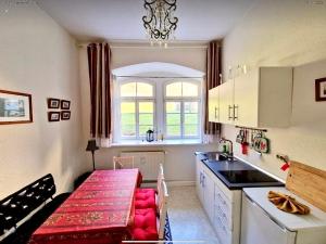 una cocina con una mesa y un banco rojo. en Elbenland Apartments Sächsische Schweiz, en Sebnitz