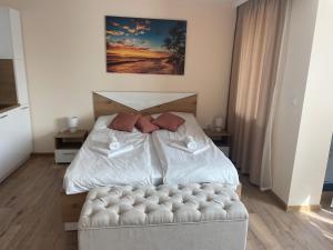 a bedroom with a white bed and a couch at Teddy Apartment in Veliko Tŭrnovo