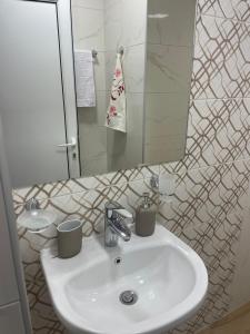 a bathroom with a white sink and a mirror at Teddy Apartment in Veliko Tŭrnovo +26 photos