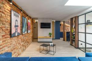 a living room with a brick wall and a blue couch at MovieCity Apartament Piotrkowska 92 in Łódź