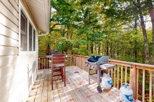 a patio with a grill and a chair on a deck at Sandy Beech in Beech Mountain