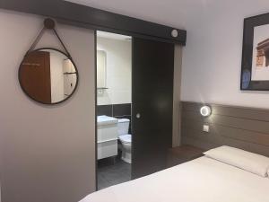 a bedroom with a bathroom with a mirror and a bed at Villa Liberté in Villejuif