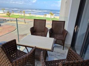 einen Tisch und Stühle mit Blick auf den Strand in der Unterkunft Port Said city, Damietta Port Said coastal road num2996 in Port Said