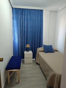 Un dormitorio con una cama y una cortina azul. en Palmeras del Sur Juan, en Playa de las Américas 21 fotos más