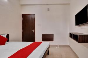 een slaapkamer met een bed en een televisie. bij OYO Flagship 81553 Green Residency in Bangalore