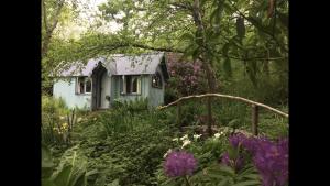 a small house in the middle of a garden at Magical Tabernacle in a Beautiful Setting with Hot Tub in Bude