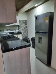 een keuken met een koelkast en een fornuis bij Casa central, segundo piso con parqueadero in Norcasia