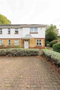 a house with a brick driveway in front of it at Quiet 2 bed flat in SW London Parking Inc in Teddington