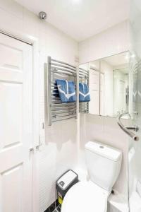 a white bathroom with a toilet and a mirror at Quiet 2 bed flat in SW London Parking Inc in Teddington