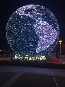 a sign with a globe of the earth at night at TRIANGLE D OR 55m2 en bord de plage in Saint-Raphaël